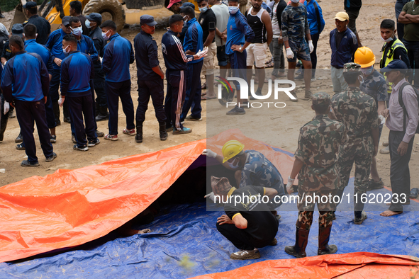 Family members identify the recovered bodies of bus passengers buried in a landslide in Jhyaple Khola, Dhading District, Nepal, on September...