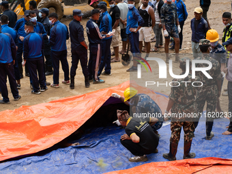 Family members identify the recovered bodies of bus passengers buried in a landslide in Jhyaple Khola, Dhading District, Nepal, on September...