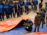 Family members identify the recovered bodies of bus passengers buried in a landslide in Jhyaple Khola, Dhading District, Nepal, on September...