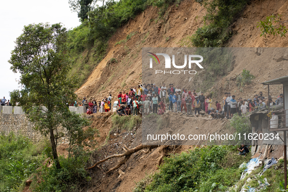 Family members wait to identify the recovered bodies of bus passengers buried in a landslide in Jhyaple Khola, Dhading District, Nepal, on S...