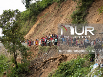 Family members wait to identify the recovered bodies of bus passengers buried in a landslide in Jhyaple Khola, Dhading District, Nepal, on S...