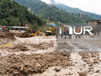 Rescue teams conduct search operations at Jhyaple Khola, Dhading District, Nepal, on September 29, 2024, after passenger buses are buried in...