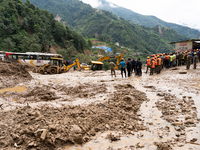 Rescue teams conduct search operations at Jhyaple Khola, Dhading District, Nepal, on September 29, 2024, after passenger buses are buried in...