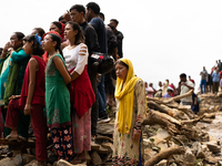 Spectators watch as the rescue teams conduct search operations at Jhyaple Khola, Dhading District, Nepal, on September 29, 2024, after passe...