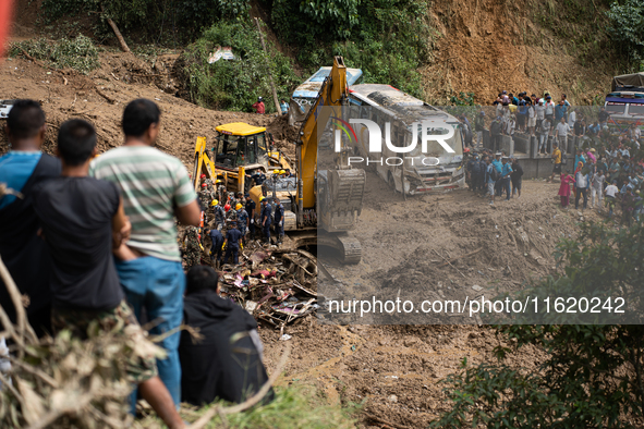 Rescue teams conduct search operations at Jhyaple Khola, Dhading District, Nepal, on September 29, 2024, after passenger buses are buried in...