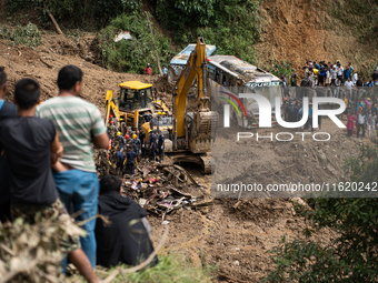 Rescue teams conduct search operations at Jhyaple Khola, Dhading District, Nepal, on September 29, 2024, after passenger buses are buried in...