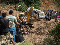 Rescue teams conduct search operations at Jhyaple Khola, Dhading District, Nepal, on September 29, 2024, after passenger buses are buried in...