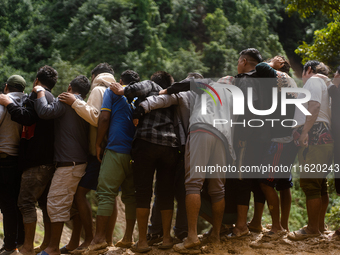 Spectators watch as the rescue teams conduct search operations at Jhyaple Khola, Dhading District, Nepal, on September 29, 2024, after passe...