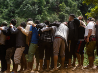 Spectators watch as the rescue teams conduct search operations at Jhyaple Khola, Dhading District, Nepal, on September 29, 2024, after passe...