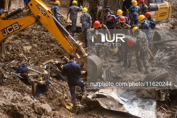 Rescue teams conduct search operations at Jhyaple Khola, Dhading District, Nepal, on September 29, 2024, after passenger buses are buried in...