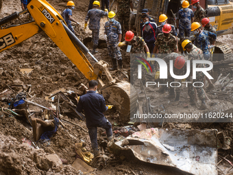 Rescue teams conduct search operations at Jhyaple Khola, Dhading District, Nepal, on September 29, 2024, after passenger buses are buried in...