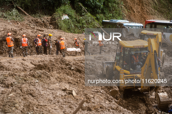 Rescue teams recover the dead body of bus passengers buried in a landslide in Jhyaple Khola, Dhading District, Nepal, on September 29, 2024....