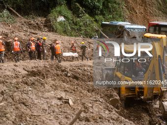 Rescue teams recover the dead body of bus passengers buried in a landslide in Jhyaple Khola, Dhading District, Nepal, on September 29, 2024....