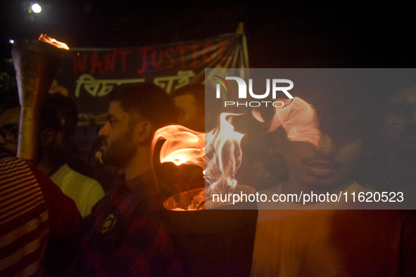 Doctors march with burning torches and shout slogans during a protest against the rape and murder of a PGT woman doctor at Government-run R...