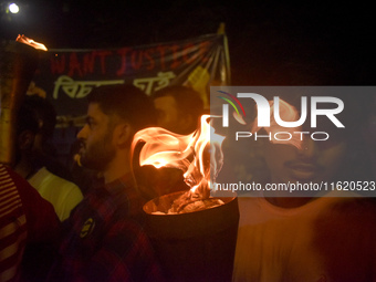 Doctors march with burning torches and shout slogans during a protest against the rape and murder of a PGT woman doctor at Government-run R...