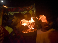 Doctors march with burning torches and shout slogans during a protest against the rape and murder of a PGT woman doctor at Government-run R...