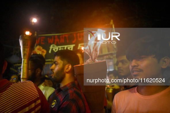 Doctors march with burning torches and shout slogans during a protest against the rape and murder of a PGT woman doctor at Government-run R...