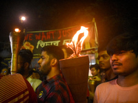 Doctors march with burning torches and shout slogans during a protest against the rape and murder of a PGT woman doctor at Government-run R...