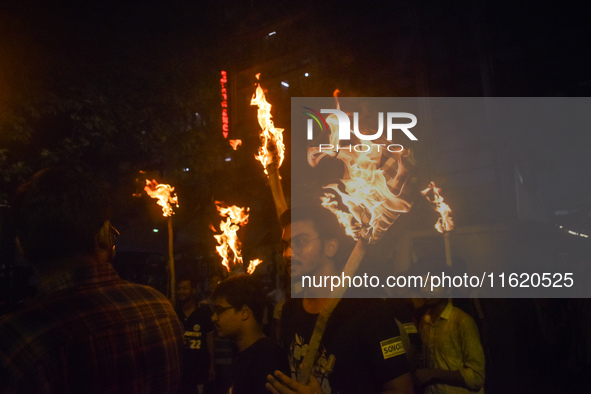 Doctors march with burning torches and shout slogans during a protest against the rape and murder of a PGT woman doctor at Government-run R...