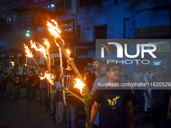 Doctors march with burning torches and shout slogans during a protest against the rape and murder of a PGT woman doctor at Government-run R...