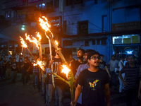 Doctors march with burning torches and shout slogans during a protest against the rape and murder of a PGT woman doctor at Government-run R...