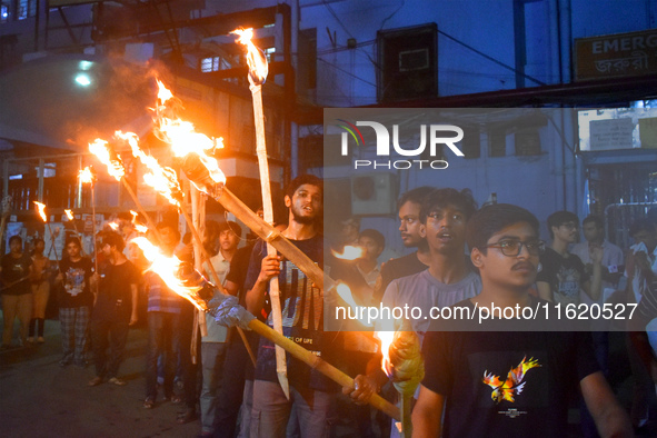 Doctors march with burning torches and shout slogans during a protest against the rape and murder of a PGT woman doctor at Government-run R...