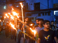 Doctors march with burning torches and shout slogans during a protest against the rape and murder of a PGT woman doctor at Government-run R...