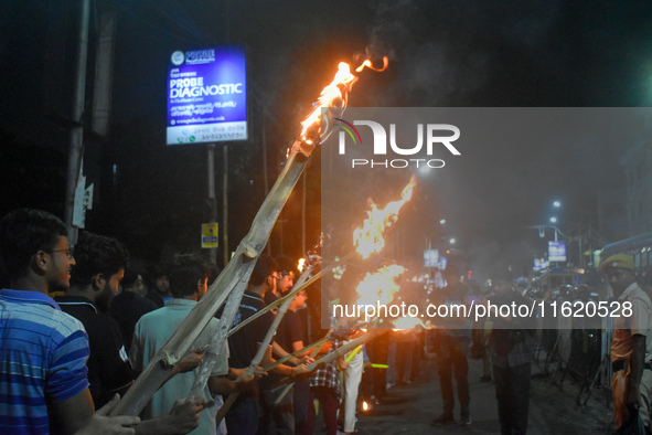 Doctors march with burning torches and shout slogans during a protest against the rape and murder of a PGT woman doctor at Government-run R...