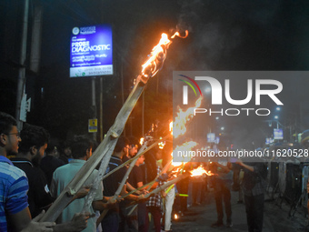 Doctors march with burning torches and shout slogans during a protest against the rape and murder of a PGT woman doctor at Government-run R...