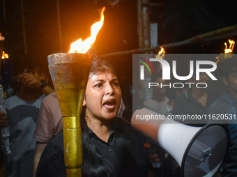 Doctors march with burning torches and shout slogans during a protest against the rape and murder of a PGT woman doctor at Government-run R...