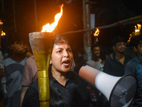 Doctors march with burning torches and shout slogans during a protest against the rape and murder of a PGT woman doctor at Government-run R...