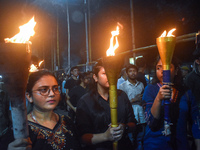 Doctors march with burning torches and shout slogans during a protest against the rape and murder of a PGT woman doctor at Government-run R...