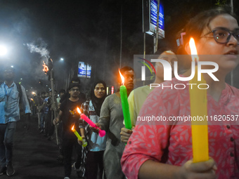 Doctors march with candles during a protest and shout slogans, protesting against the rape and murder of a PGT woman doctor at Government-ru...