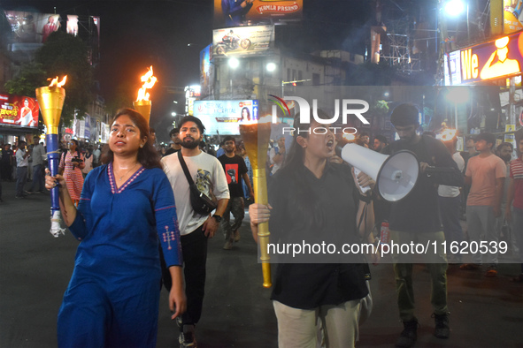 Doctors march with burning torches and shout slogans during a protest against the rape and murder of a PGT woman doctor at Government-run R...