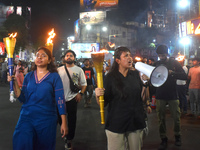 Doctors march with burning torches and shout slogans during a protest against the rape and murder of a PGT woman doctor at Government-run R...