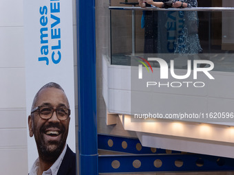 Delegates stand next to a James Cleverly banner at the Conservative Party Conference at the International Conference Centre in Birmingham, E...