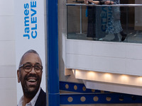 Delegates stand next to a James Cleverly banner at the Conservative Party Conference at the International Conference Centre in Birmingham, E...