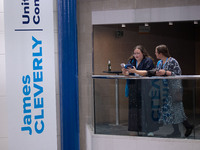 Delegates stand next to a James Cleverly banner at the Conservative Party Conference at the International Conference Centre in Birmingham, E...