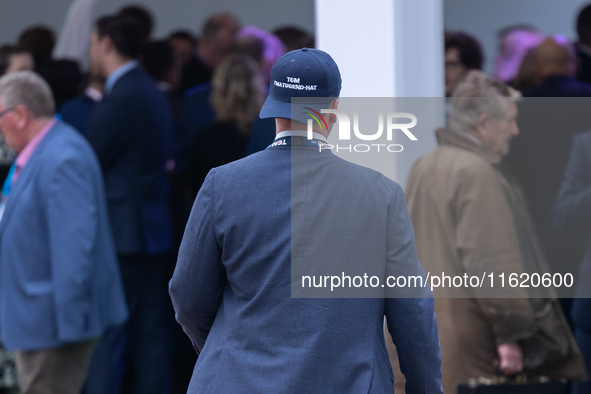 One of Tom Tugendhat's team wears a ''TOM I'M A TUGEND-HAT'' hat backwards at the Conservative Party Conference at the International Confere...