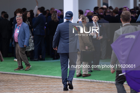 One of Tom Tugendhat's team wears a ''TOM I'M A TUGEND-HAT'' hat backwards at the Conservative Party Conference at the International Confere...