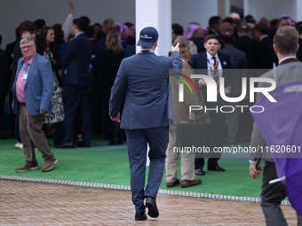 One of Tom Tugendhat's team wears a ''TOM I'M A TUGEND-HAT'' hat backwards at the Conservative Party Conference at the International Confere...