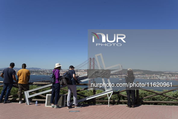 A general view of people taking pictures of the bridge from the Cristo Rei monument in Lisbon, Portugal, on September 29, 2024. Cristo Rei a...