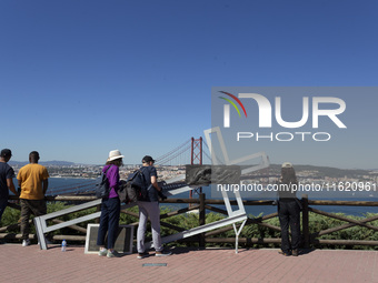 A general view of people taking pictures of the bridge from the Cristo Rei monument in Lisbon, Portugal, on September 29, 2024. Cristo Rei a...