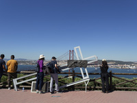 A general view of people taking pictures of the bridge from the Cristo Rei monument in Lisbon, Portugal, on September 29, 2024. Cristo Rei a...