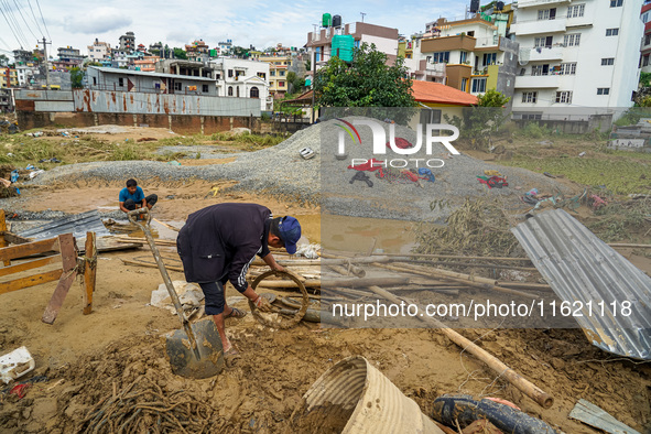 People's daily lives are affected after heavy rainfall and flooding of the Nakhu River in Lalitpur, Nepal, on September 29, 2024. People gat...