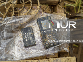 A damaged mobile phone is found while cleaning mud in the residential area along the Nakhu River bank in Lalitpur, Nepal, on September 29, 2...