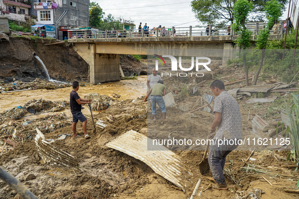 People's daily lives are affected after heavy rainfall and flooding of the Nakhu River in Lalitpur, Nepal, on September 29, 2024. People cle...