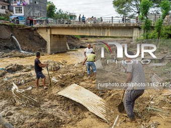 People's daily lives are affected after heavy rainfall and flooding of the Nakhu River in Lalitpur, Nepal, on September 29, 2024. People cle...