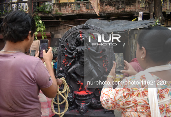 People take photos of the Durga idol outside a pottery hub ahead of the Durga Puja festival in Kolkata, India, on September 29, 2024. 