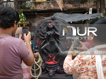 People take photos of the Durga idol outside a pottery hub ahead of the Durga Puja festival in Kolkata, India, on September 29, 2024. (